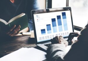 Man looking at graph on laptop